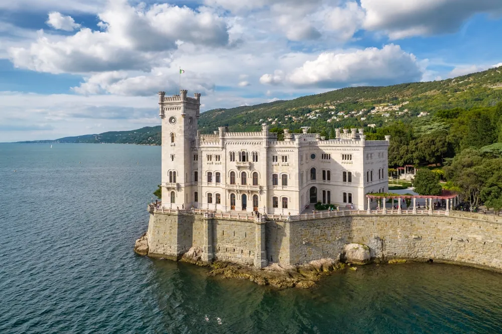 Aerial view of the Miramare Castle at the Adriatic sea coast in Italy. Drone revealing footage of the Miramare castle near Trieste, Italy. Italian summer holidays travel destination