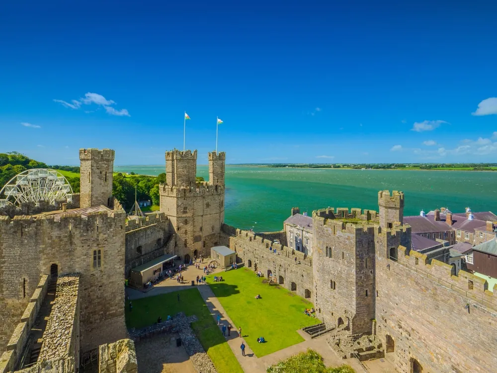 Aerial view of the Outer Ward of Caernarfon Castle and the blue Menai Strait (Caernarfon, Wales, United Kingdom)