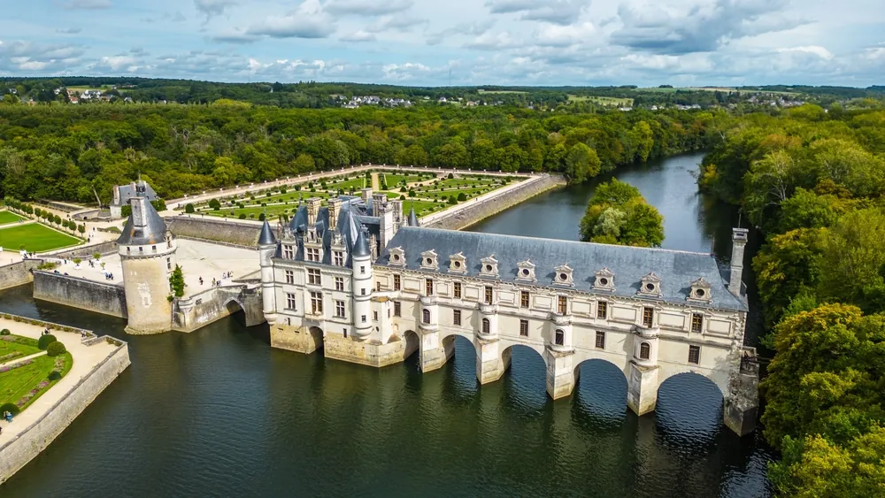 Aerial view of Château de Chenonceau, one of the most famous Loire Valley castles in France. Renaissance architecture spanning the River Cher, surrounded by lush forests and beautifully landscape