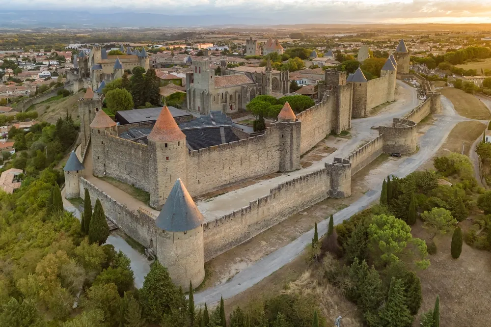 Aerial view of the medieval city of Carcassonne town and its fortress castle at sunrise, southern France.Famous historic fortress with its iconic medieval towers in the beautiful morning light