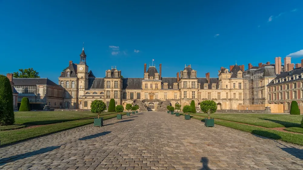 Royal hunting castle Fontainbleau timelapse hyperlapse front view with entrance. Moving toward. Palace of Fontainebleau - one of largest royal chateaux in France, UNESCO World Heritage Site.