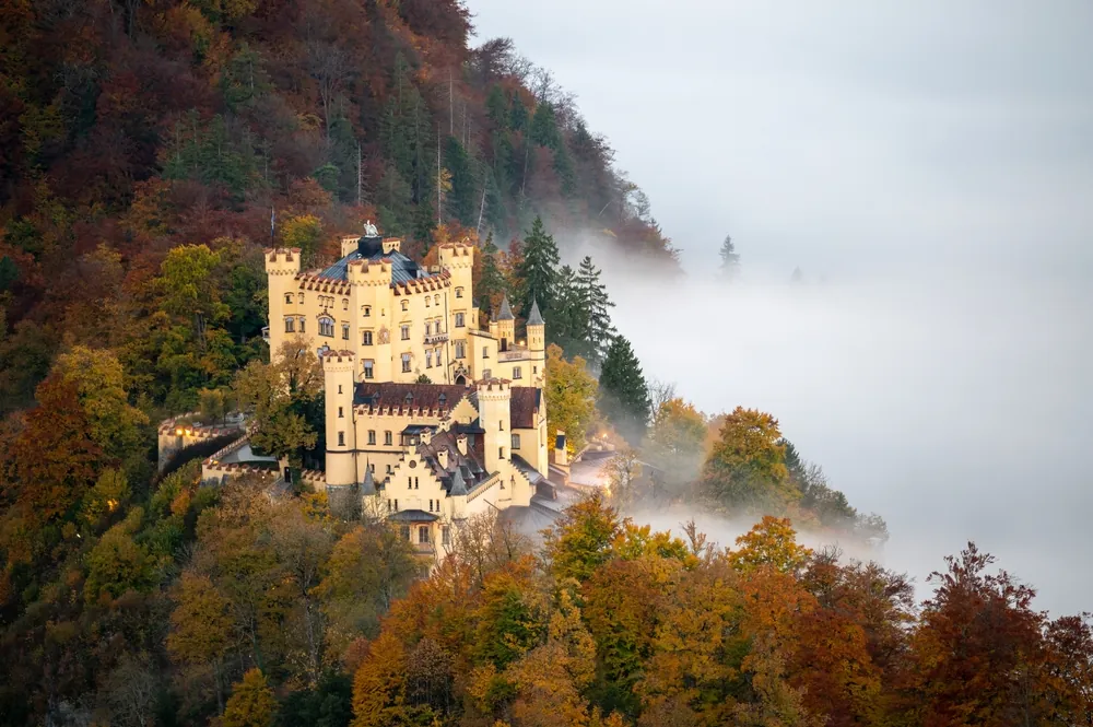 An aerial view of the Hohenschwangau Castle surrounded by mist in Germany