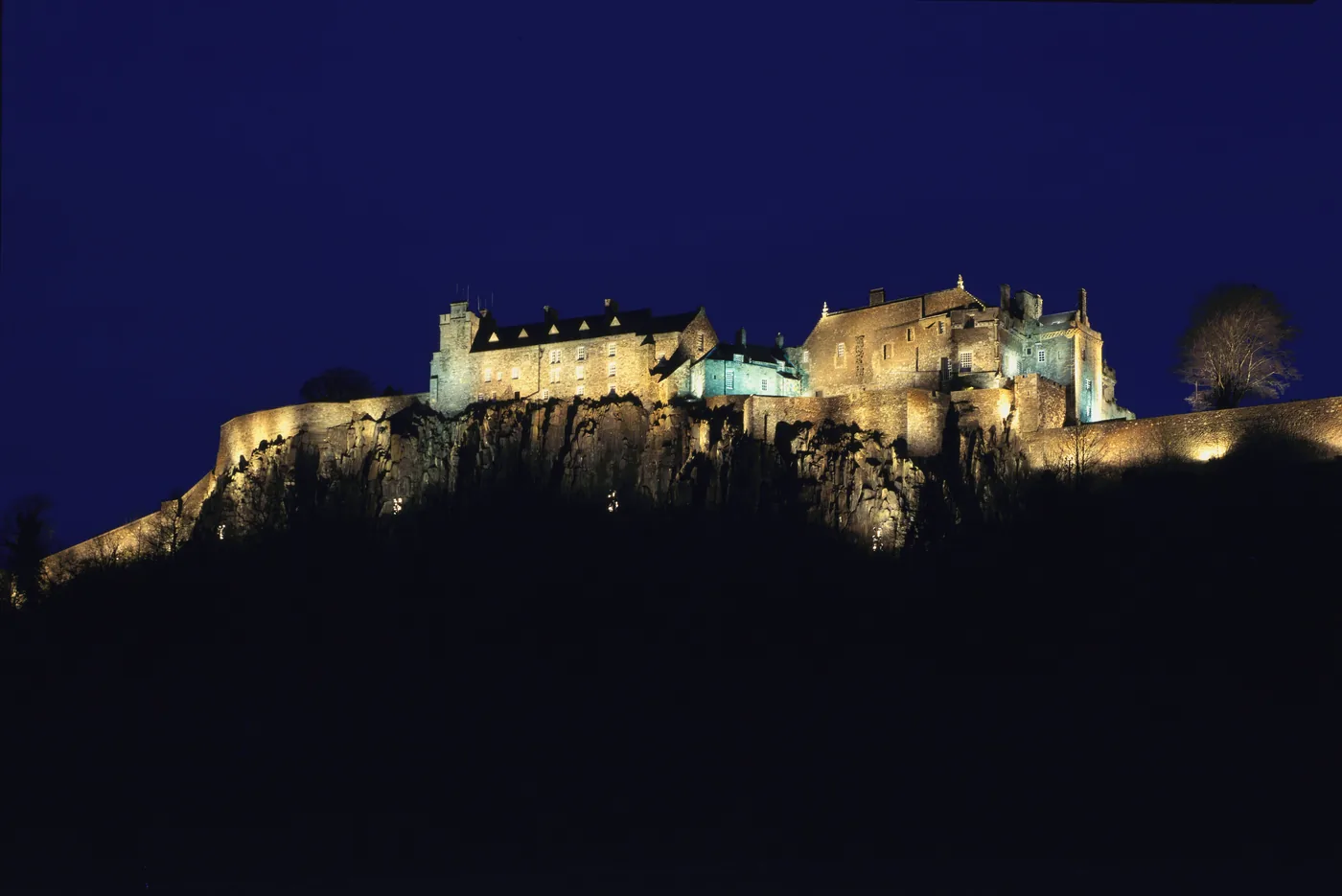Stirling Castle, a haunted Scottish castle, floodlit at night